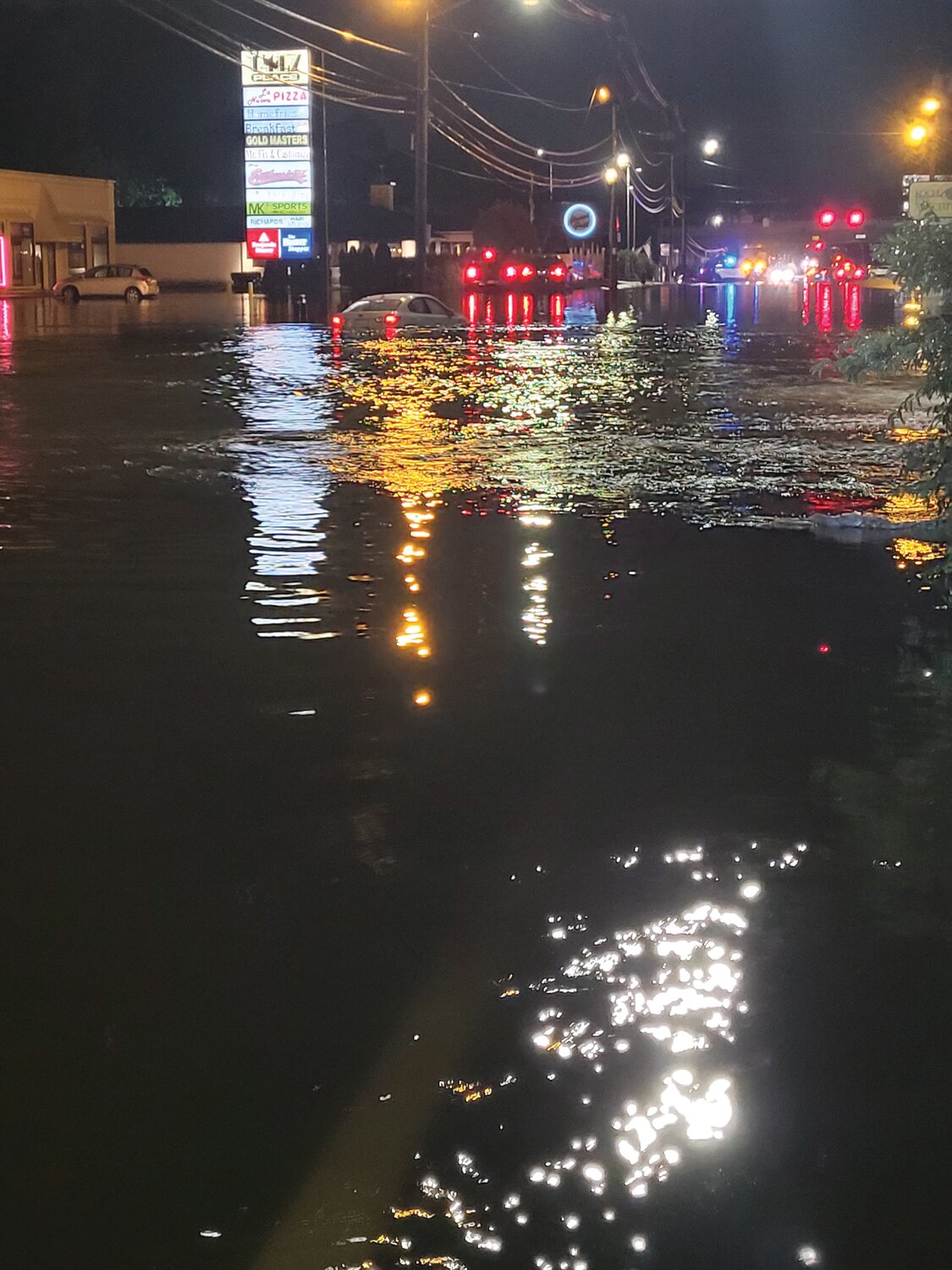 LIKE A BOBBER: Later Monday night, a stranded vehicle continued to float around a flooded Atwood Avenue as the waters rose, but tow trucks were unable to reach it until the waters receded.